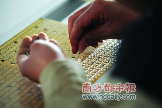工人忙著安裝用于燈具發光的LED燈珠，這類工作處于LED燈具生產的最下游。資料圖